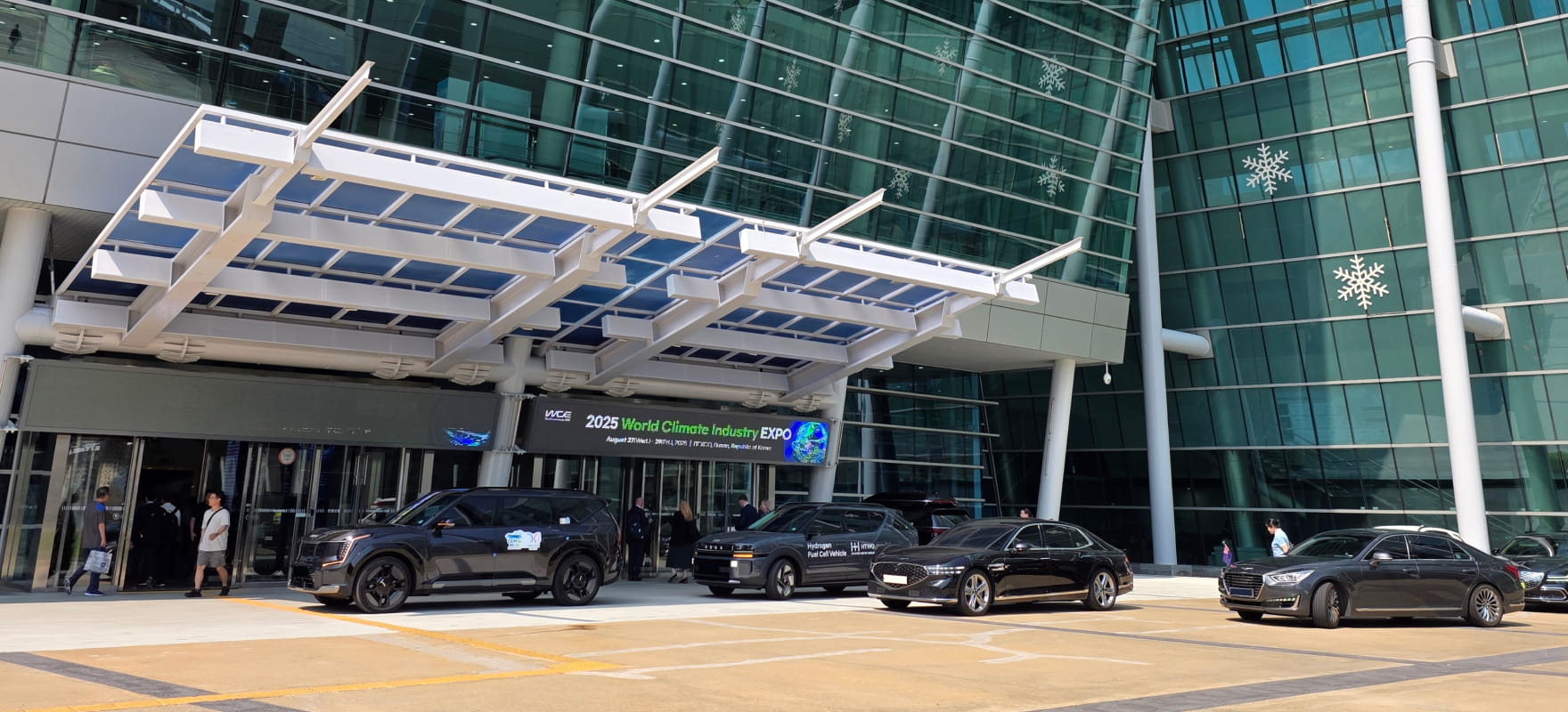 Official protocol vehicles parked under the BEXCO canopy with the 2025 World Climate Industry EXPO banner in the background.